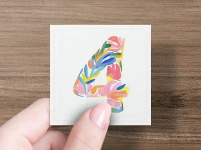 Hand holds square card with number 4 in colorful floral paint design.