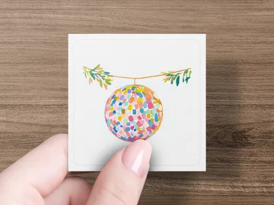 Colorful abstract orb with hanging branches on a card held by a hand.