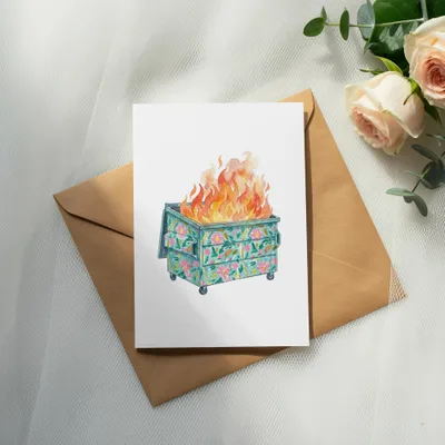 Floral dumpster fire illustration on a card, resting on an envelope.