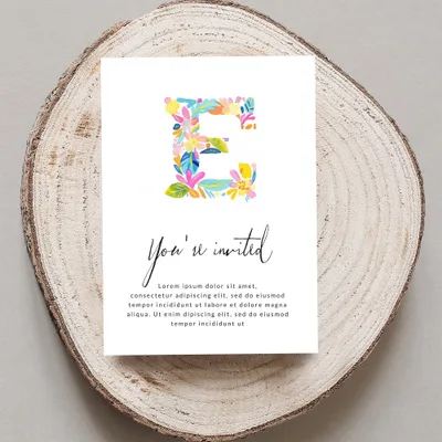 Invitation with colorful floral initial E and placeholder text.