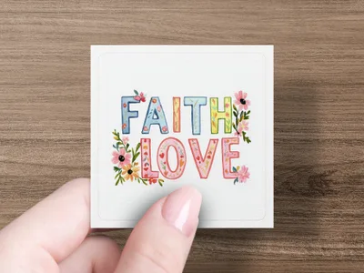 Square card with "FAITH LOVE" in colorful floral lettering held by a hand.