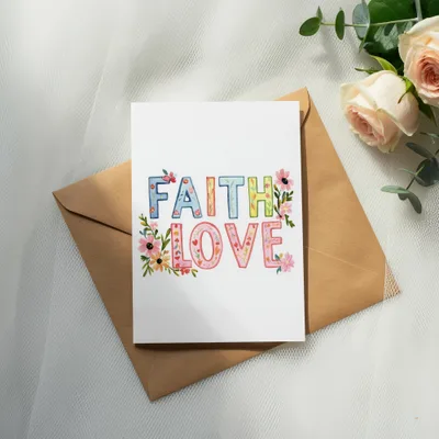 Greeting card with "FAITH LOVE" in colorful watercolor lettering.