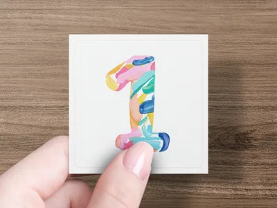 Hand holding card with colorful painted number 1.