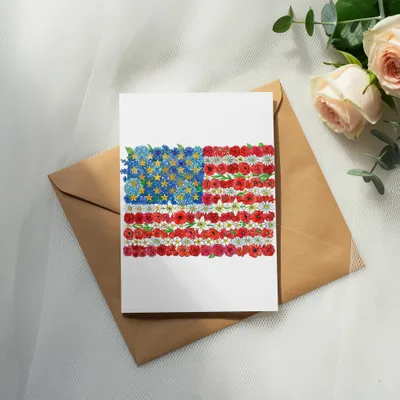 Card with American flag design made of flowers, resting on an envelope.