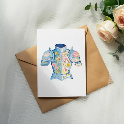 Watercolor illustration of a blue floral-decorated knight's breastplate on a card.
