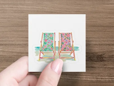 Two deck chairs with floral patterns and blue water.