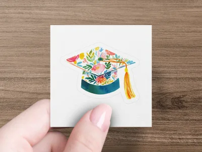 Graduation cap adorned with colorful flowers and a yellow tassel.