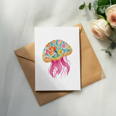 Card with watercolor jellyfish and floral details, resting on an envelope.