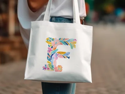 White tote bag with a colorful floral letter "F" design.