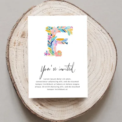 Invitation with colorful floral letter F and placeholder text.