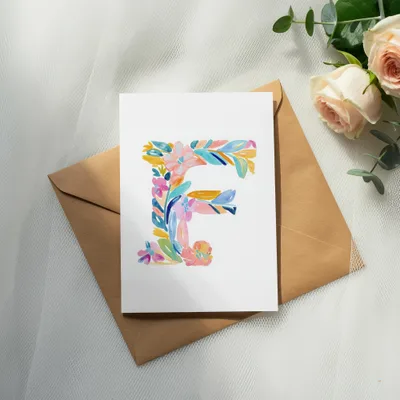 Card with a floral letter E on a brown envelope with roses.