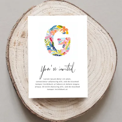 "G" initial with floral design on invitation for "You're invited" event.