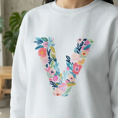 White sweatshirt with a large, colorful floral letter "V" design.