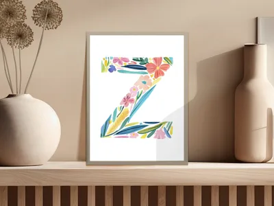 Colorful floral letter Z artwork in a minimalist frame on a shelf.