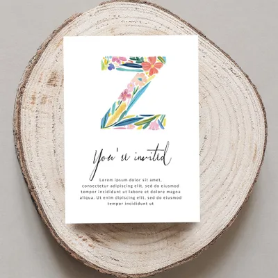 Invitation with watercolor flowers on letter Z, reading "You're invited" and placeholder text.