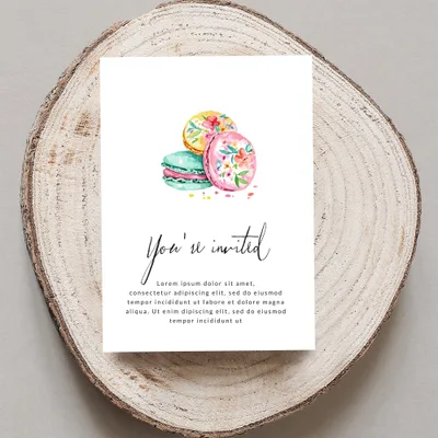 Invitation card with "You're invited" text and floral macarons.