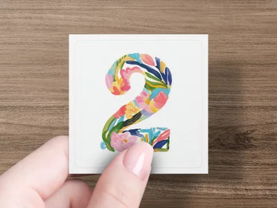 Number 2 in colorful floral watercolor painting held by a hand.