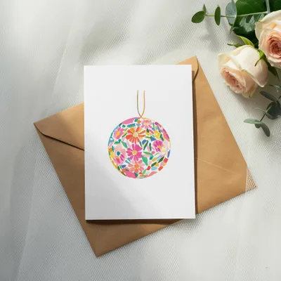 Blank card with colorful floral sphere illustration on brown envelope.