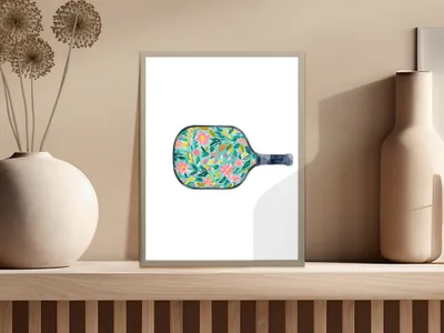 Watercolor pickleball paddle with pink, blue, and yellow floral pattern.