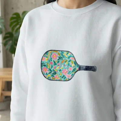 White sweatshirt with a pickleball paddle graphic featuring a floral pattern.