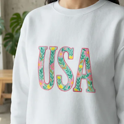 White sweatshirt with floral "USA" graphic.