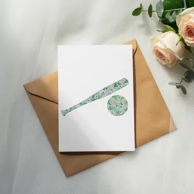 Card with floral baseball bat and ball on envelope next to roses.