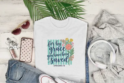 White t-shirt with "by grace you have been saved" text and floral design.