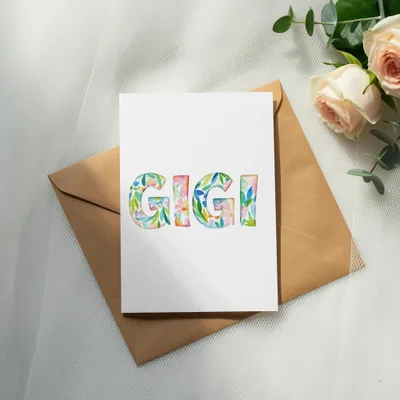 Card with floral "GIGI" lettering on kraft envelope and roses.