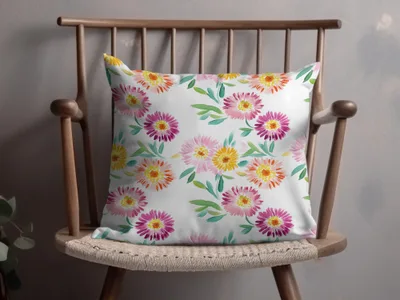 White throw pillow with a floral watercolor pattern of pink and yellow flowers.