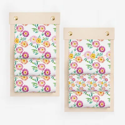 Fabric swatches with colorful floral pattern, displayed on wooden boards.