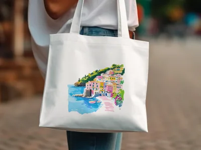 White canvas tote bag with watercolor illustration of a colorful coastal village.