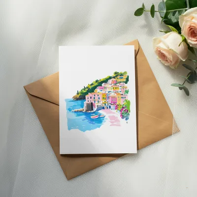 Watercolor painting of colorful Italian coastal village on envelope.