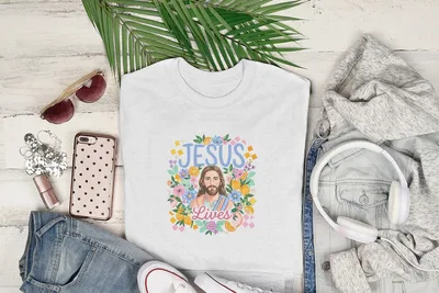 White t-shirt with "Jesus Lives" floral design and fruit accents.