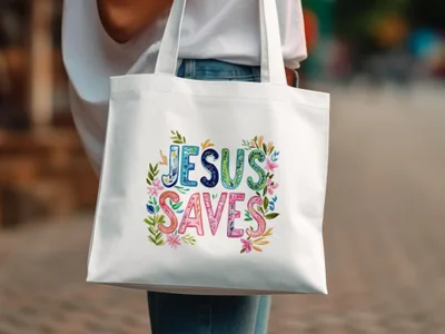 White tote bag with "Jesus Saves" in colorful floral lettering.