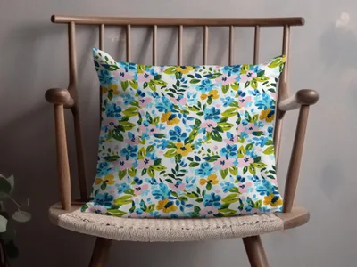 Floral pattern pillow on a wooden chair.