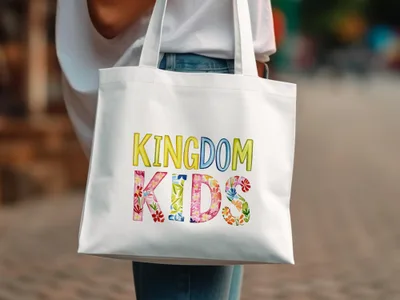 White tote bag with colorful "Kingdom Kids" text and floral accents.