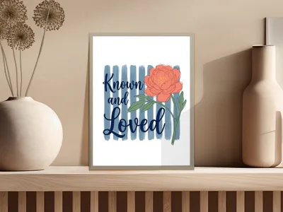 Framed art print with coral peony and "Known and Loved" text on blue stripes.