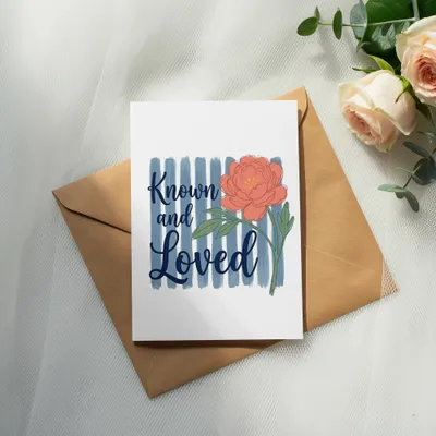 Card with coral peony and "Known and Loved" text on blue stripes.