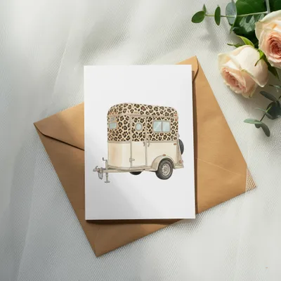 Watercolor painting of a horse trailer with leopard print accents on a card.