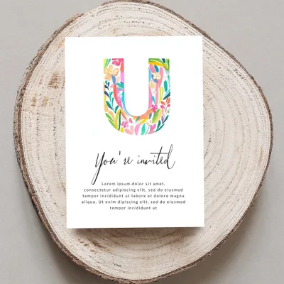 Watercolor letter U on invitation with "You're invited" and placeholder text.