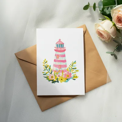 Watercolor lighthouse with flowers on a brown envelope and roses.