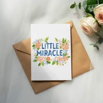 Card with "Little Miracle" text surrounded by watercolor flowers.