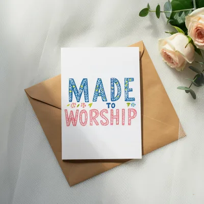 Card with "MADE TO WORSHIP" text, on a brown envelope with roses.