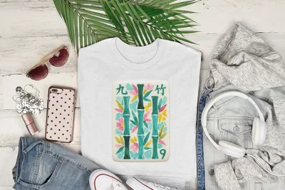 White t-shirt with bamboo and floral illustration on a flat lay.