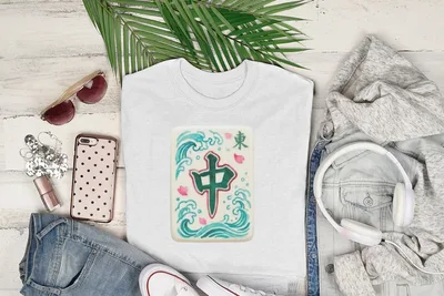 White t-shirt with green mahjong tile on wavy blue background, styled with jeans and headphones.