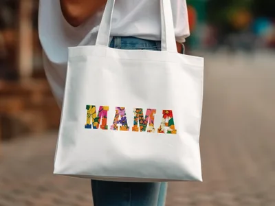 White tote bag with "MAMA" in colorful floral lettering.