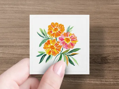 Watercolor painting of three marigold flowers with green leaves on a card held by a hand.