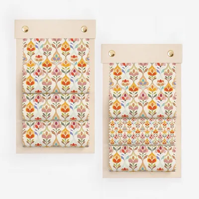 Two swatches of fabric with a repeating floral pattern in red, orange, and blue.