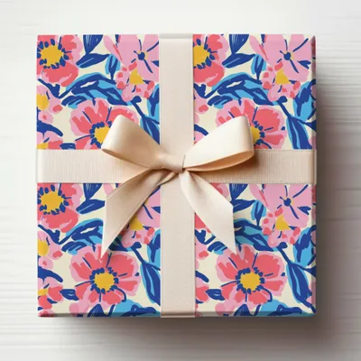 Gift box wrapped in a floral pattern with a cream ribbon bow.