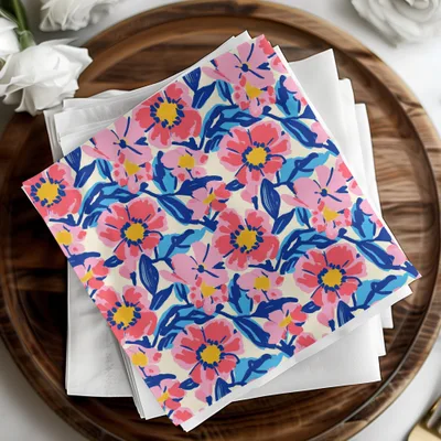 Floral patterned napkins with pink, blue, and yellow flowers on a wooden tray.
